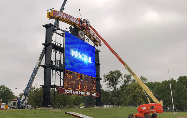 Sign Installers Installing components on a large football scoreboard at Concordia College Moorhead MN